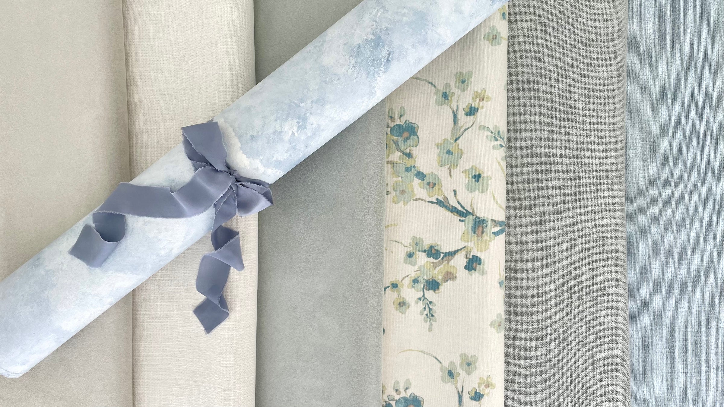 Rolled up light blue, champagne, gray, and floral styling mats from Champagne & GRIT