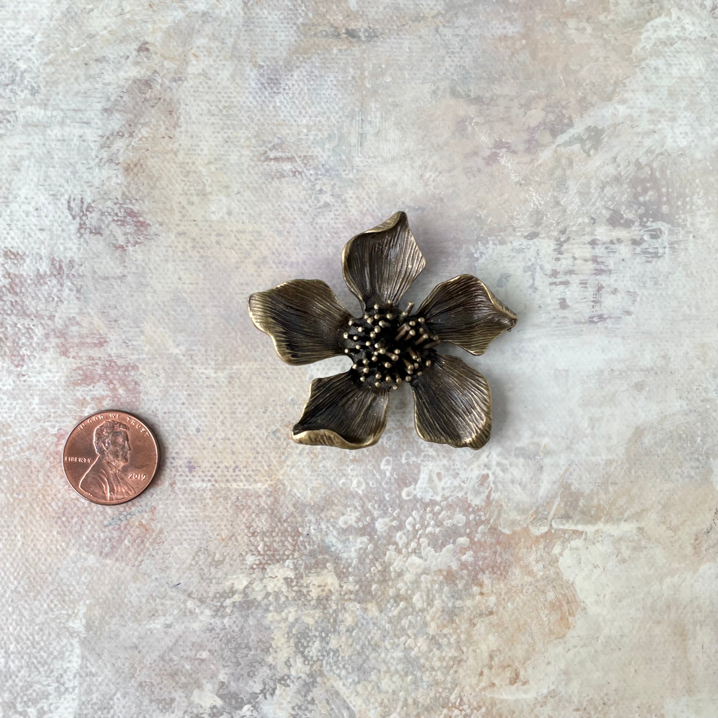 1 larger metal styling flower with penny beside for size reference - flat lay props from Champagne & GRIT