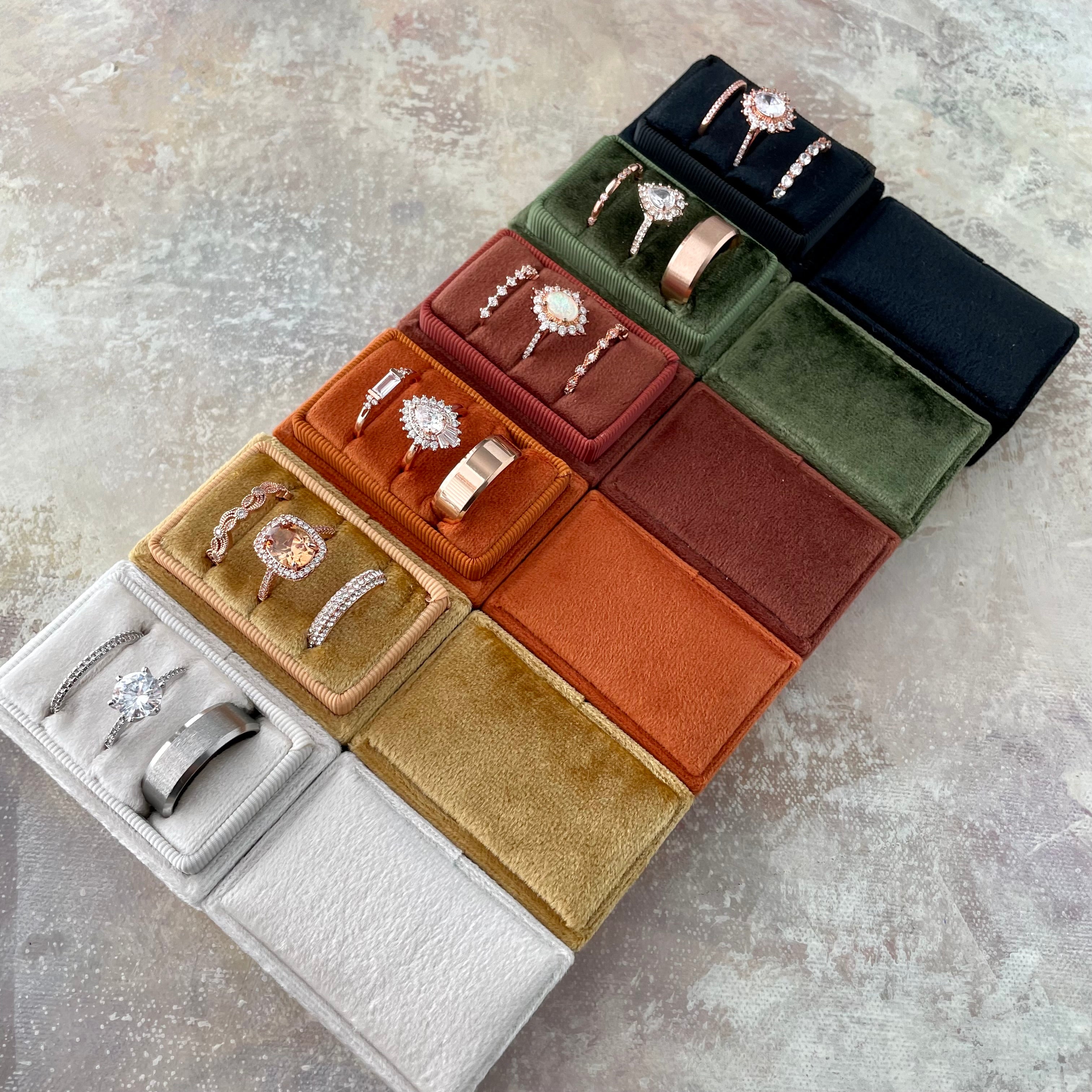 Variety of colored triple slot ring boxes - diamond white, gold, burnt orange, rust, olive green, black - Wedding Flat lay props from Champagne & GRIT