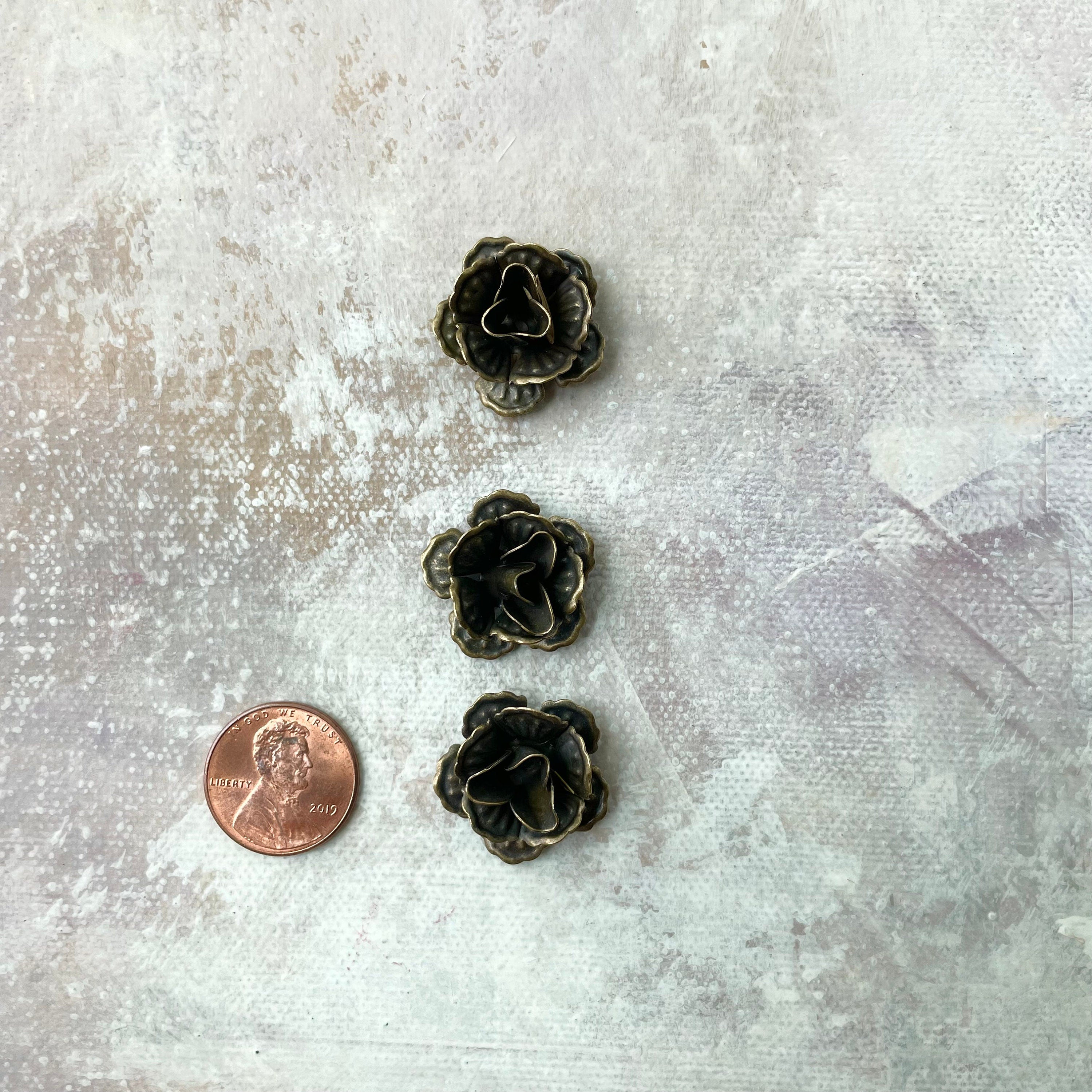 3 mini bronze styling flowers with penny beside for size reference - Flat lay props from Champagne & GRIT 