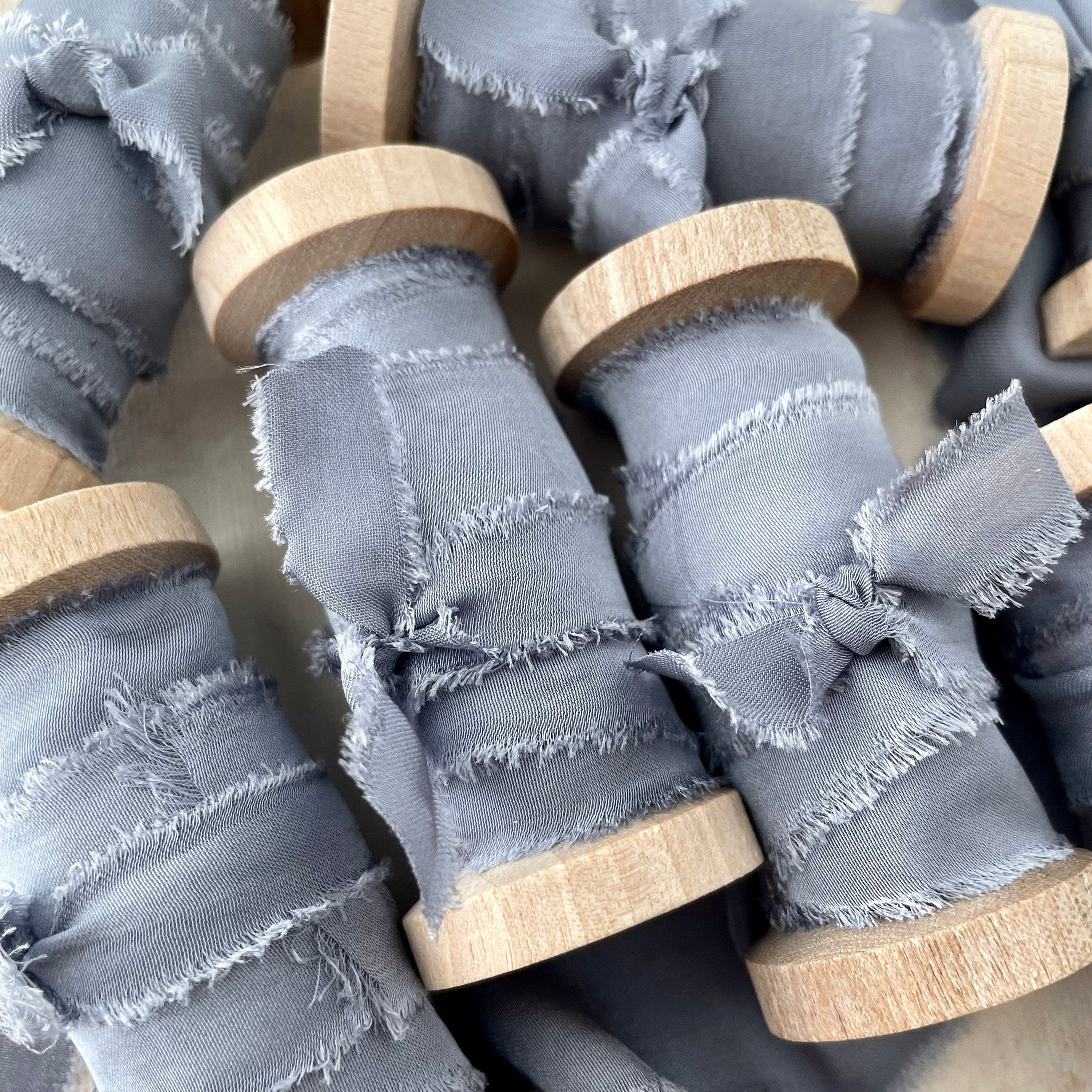 Close up of 6 Dusty Blue Ribbon rolls - flat lay props from Champagne & GRIT