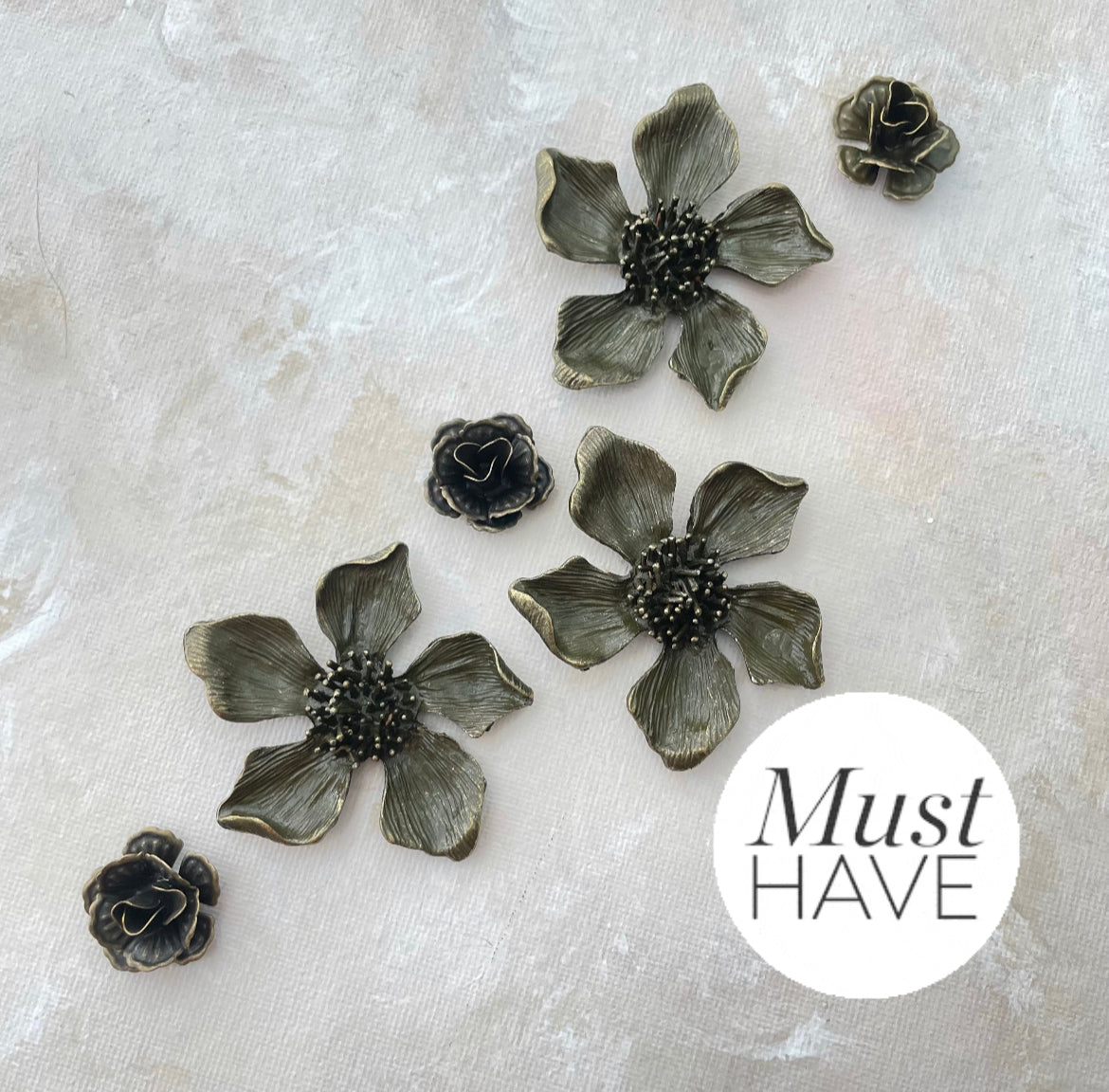 Three large Metal styling flowers and three small metal styling flowers, flowers have a  Brown Finish with touches of gold must have styling props from Champagne & GRIT