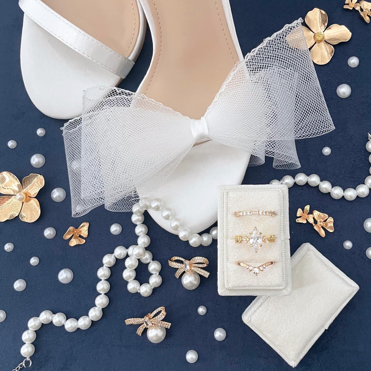 Flat Lay detail on a navy blue back ground.  Showcasing a white rectangle ring ring box with 3 slots.