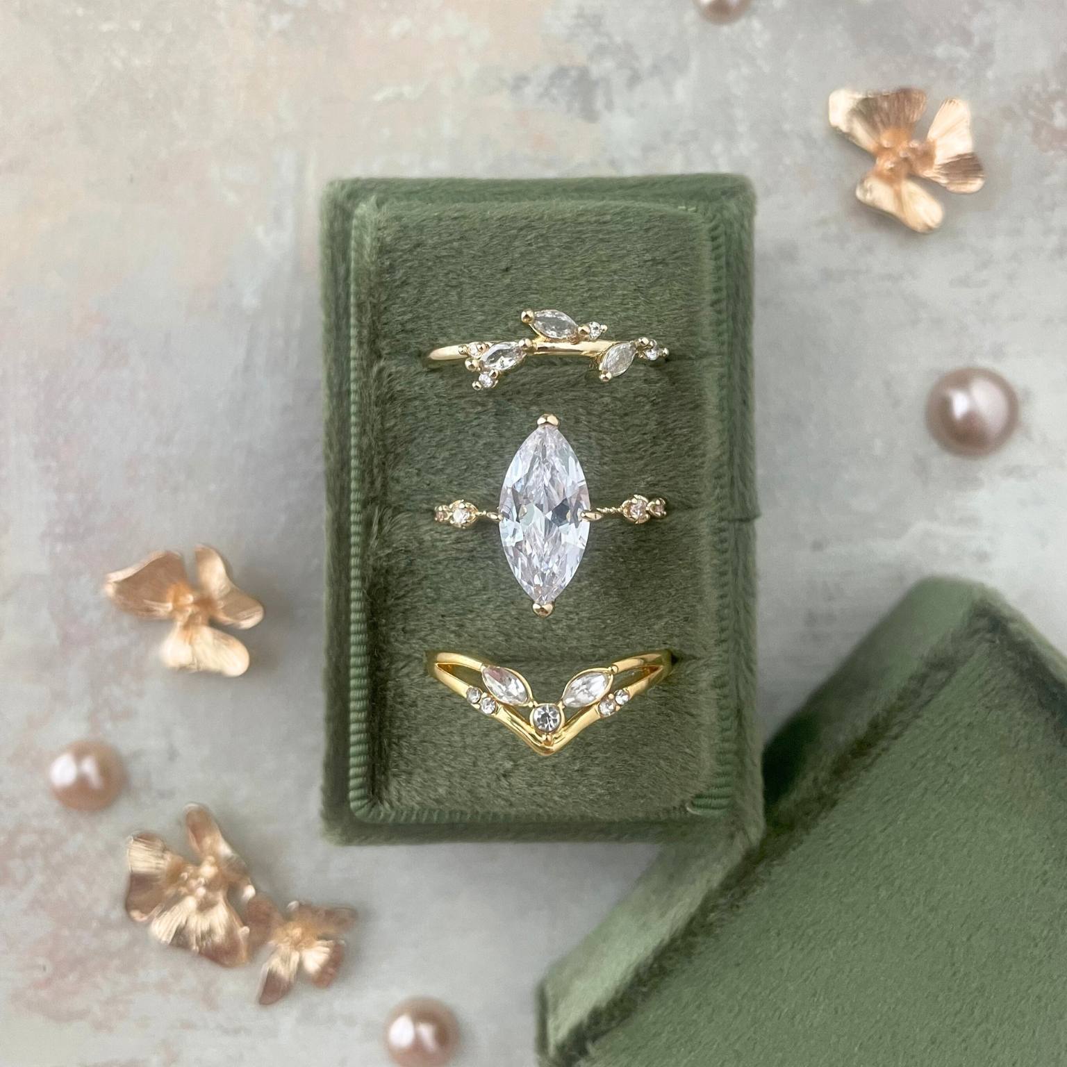 Set of gold and diamond rings in a 3 slot ring rectangle ring box.  styled on a neutral flat lay mat.  