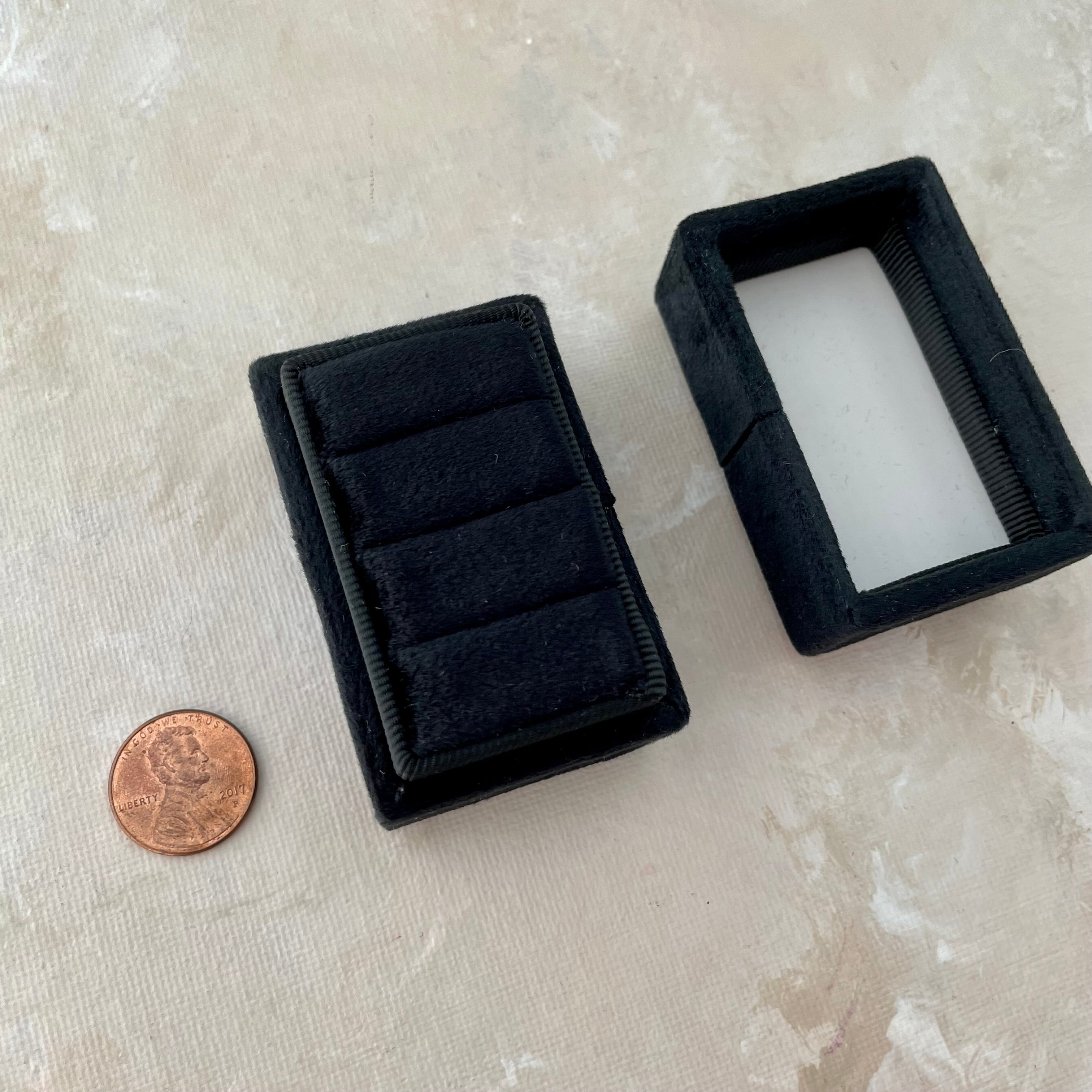 Black triple ring box without rings inside, penny beside for size reference - Flat Lay Props from Champagne & GRIT