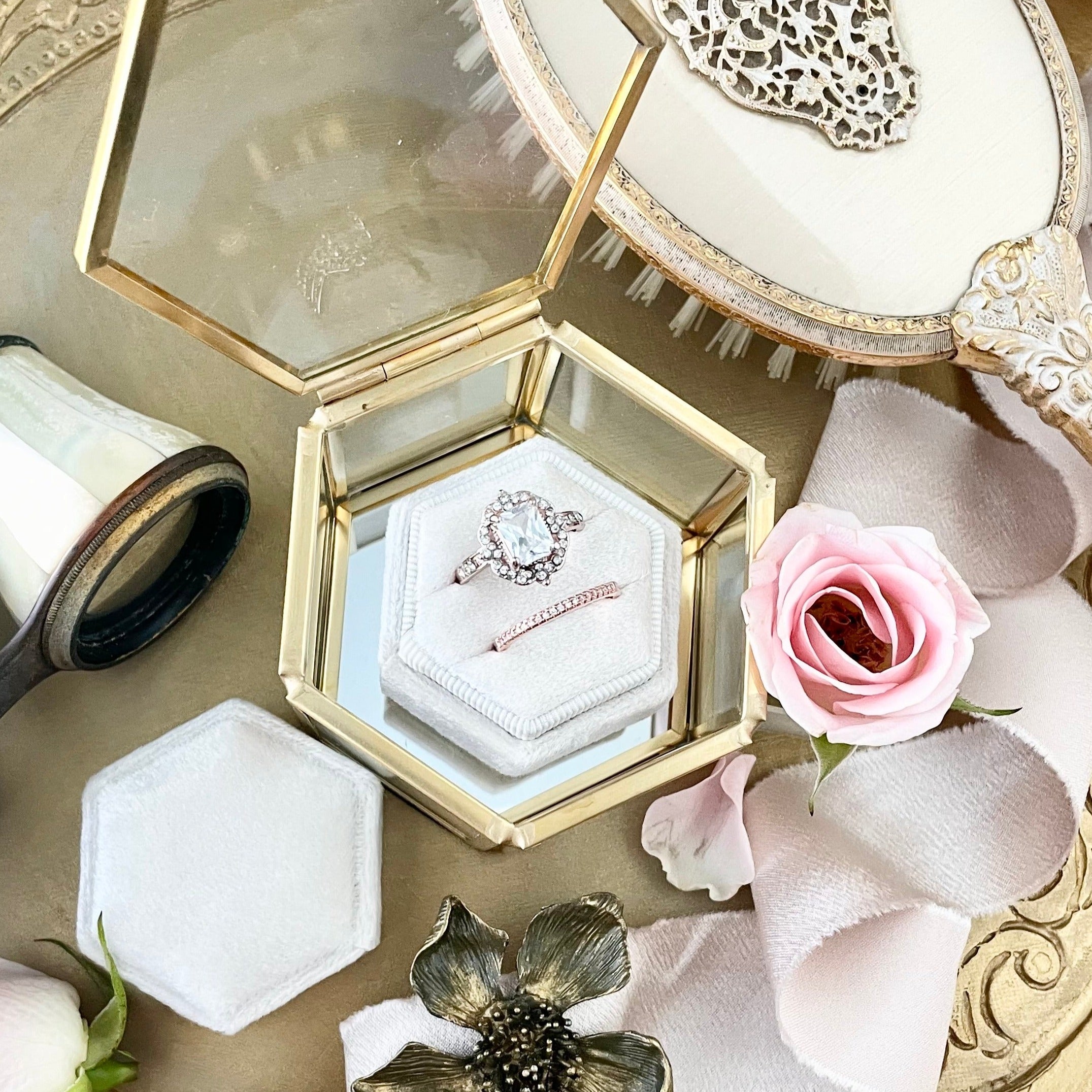 White ring box styled with gold and glass dish, vintage brush, and vintage opera glasses - Wedding Flat lay props from Champagne & GRIT