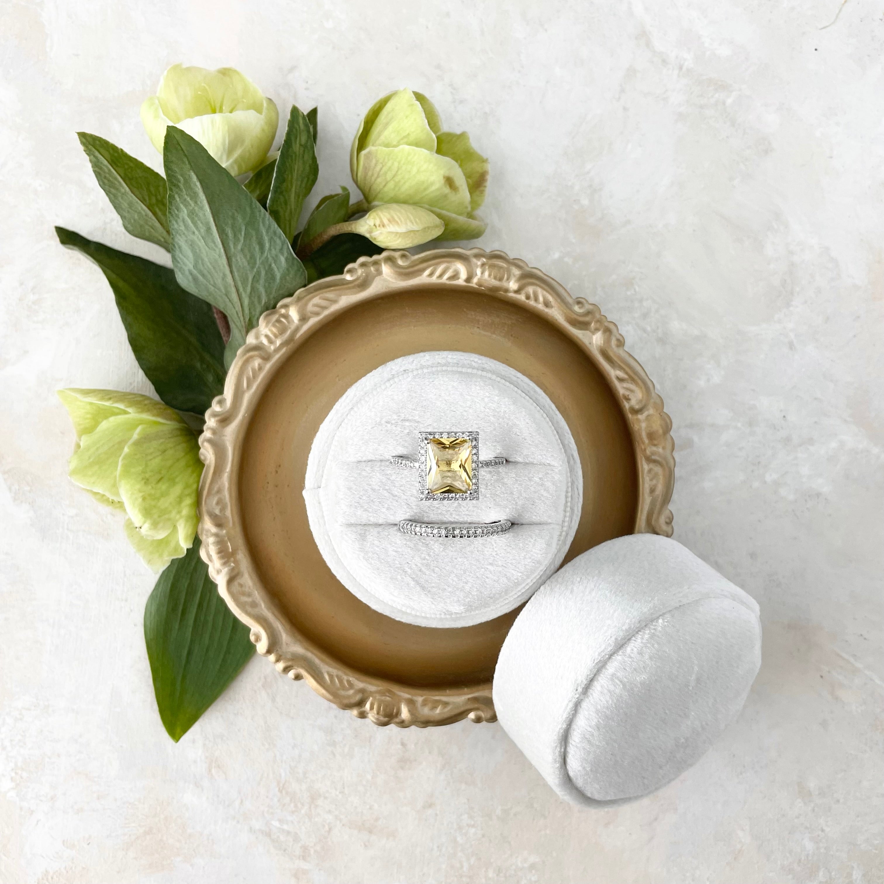 White ring box in gold dish styled with green florals - Wedding Flat lay props from Champagne & GRIT