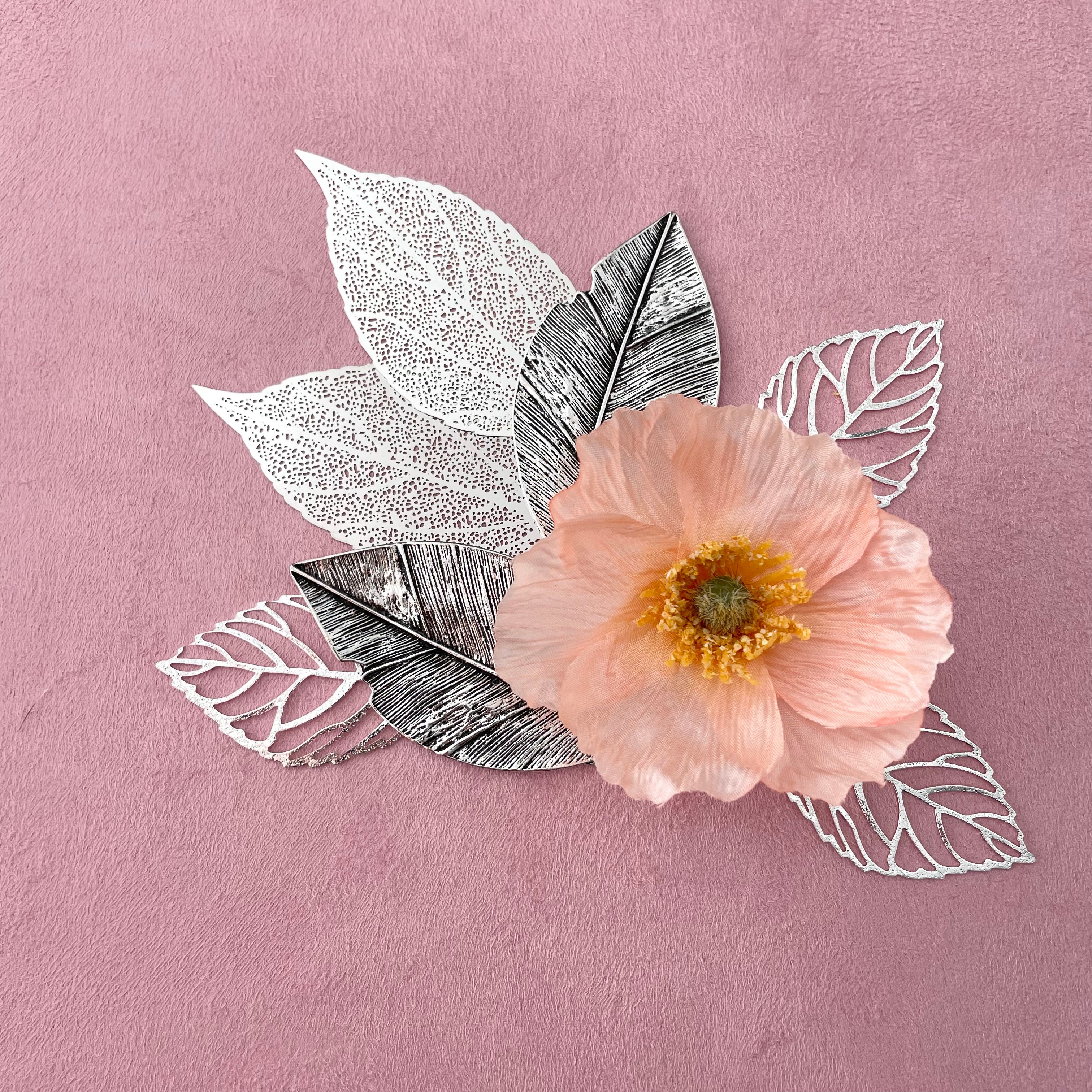 7 styling leaves including 3 silver leaves, 2 silver leaves that are larger, and 2 large silver with dark accent leaves with one flower on top - wedding flat lay props from Champagne & GRIT