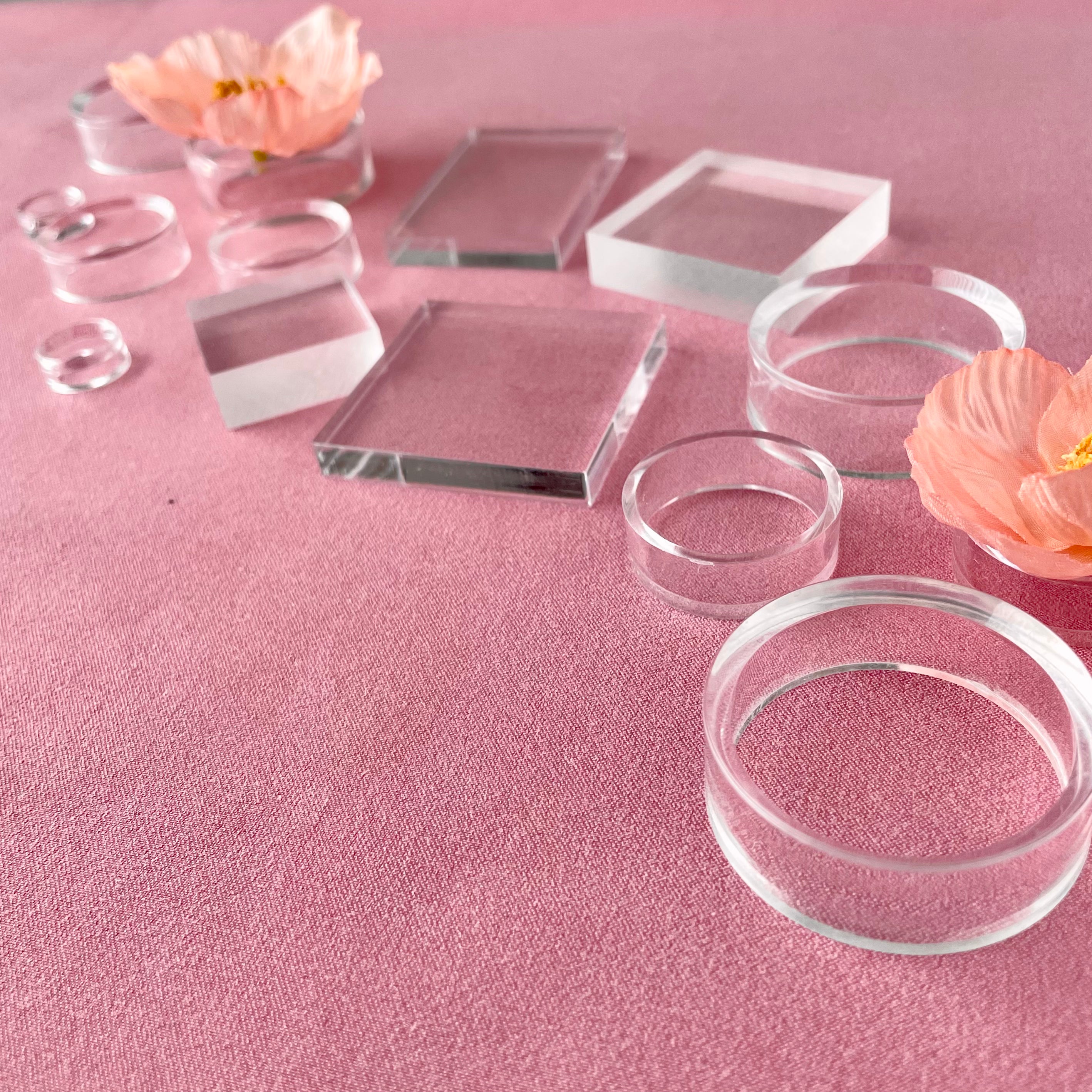 Side angle photo of Clear Acrylic Styling Block Set & Floral Risers for Flat Lays on a Dusty Pink Styling Mat from Champagne & GRIT