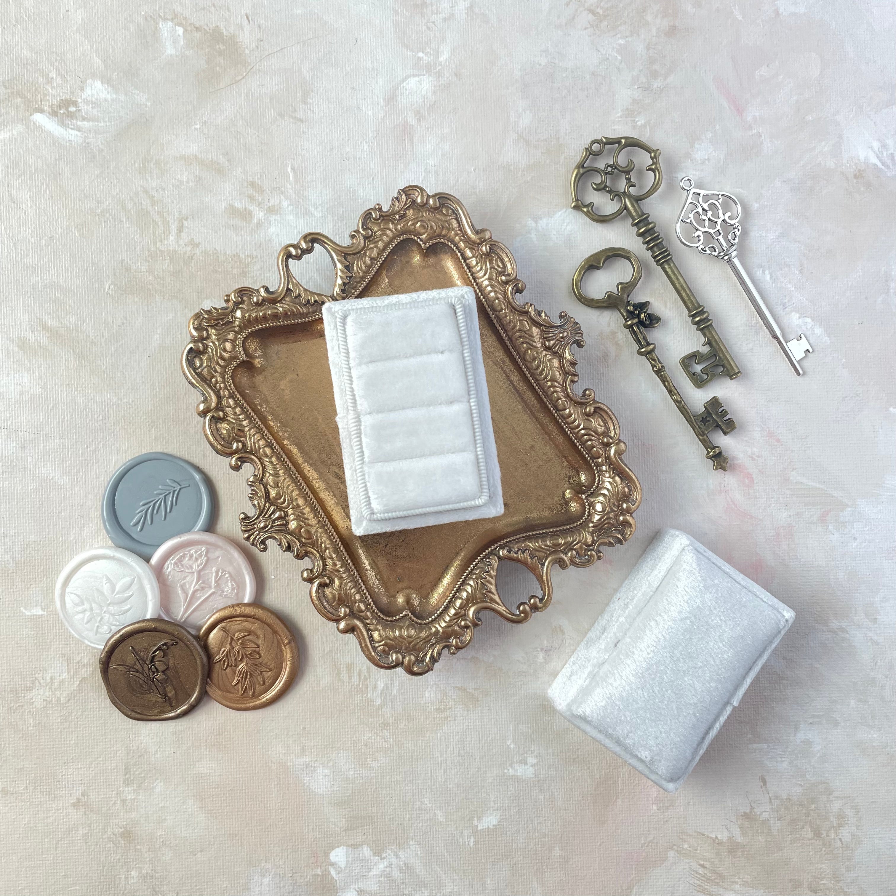 5 Classic neutral color pallet Wax Seals beside white 3 slot ring box on gold tray and three vintage keys - wedding flat lay props from Champagne & GRIT