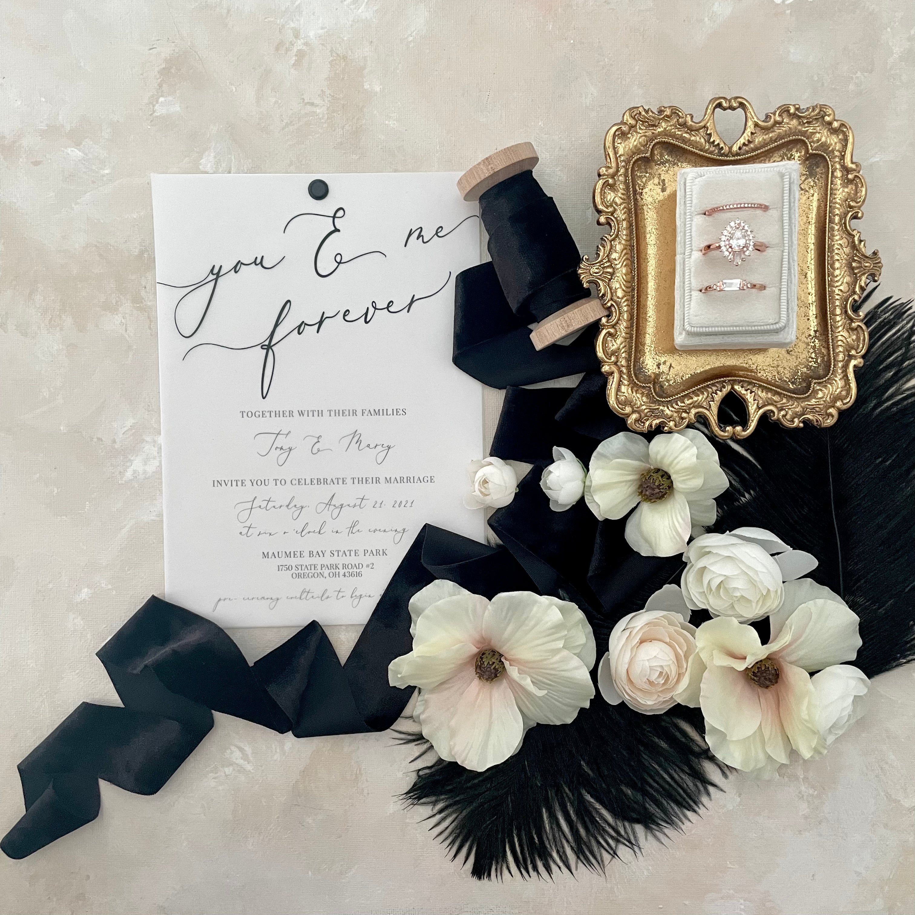 White triple slot ring box on vintage gold tray styled with wedding invitation, black modern ribbon and ivory florals  - Wedding Flat lay props from Champagne & GRIT