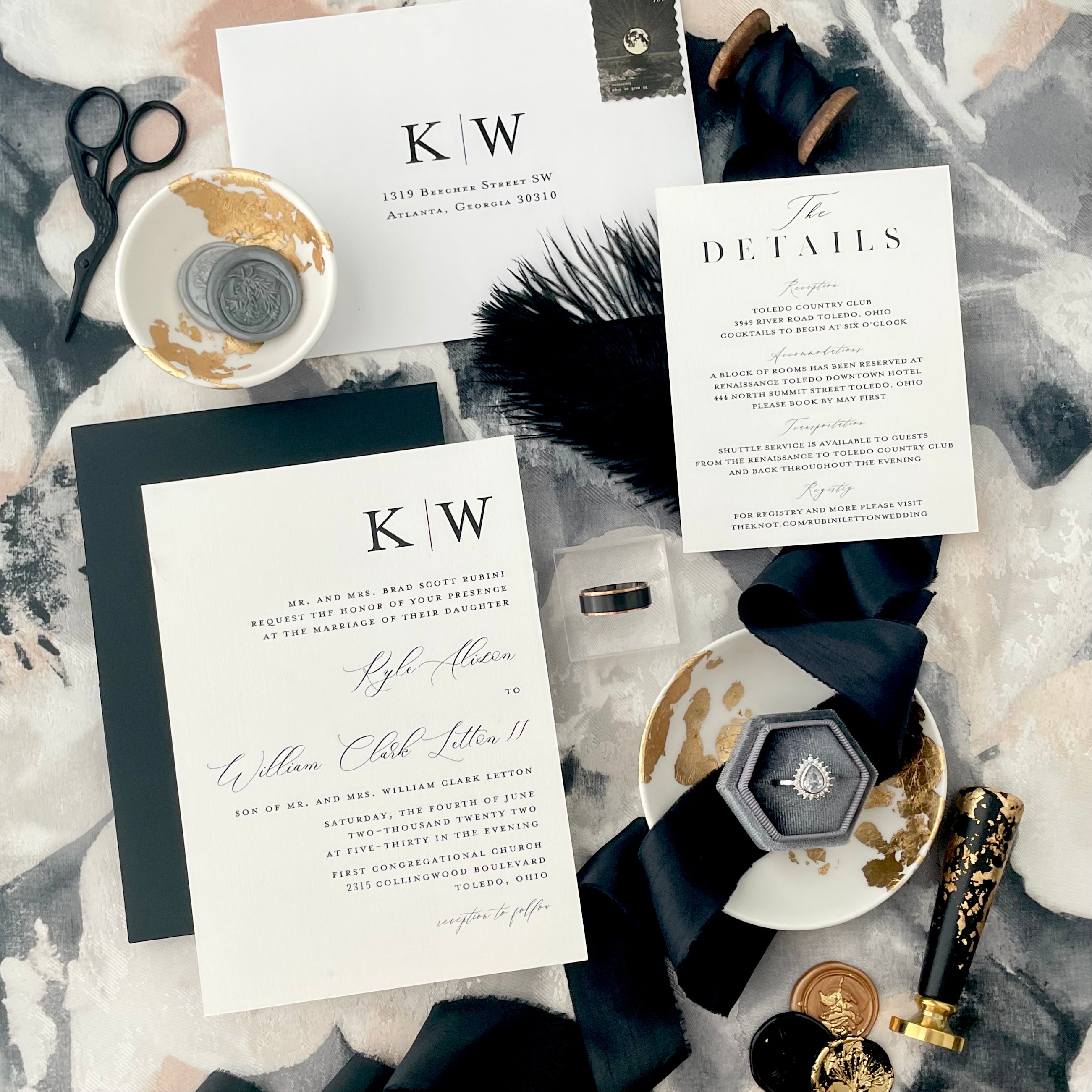 Example of how to style modern black scissors with wedding flay lay props including wedding invitation, grey ring box, wax seals and stamp and black ribbon - Wedding Flat lay props from Champagne & GRIT