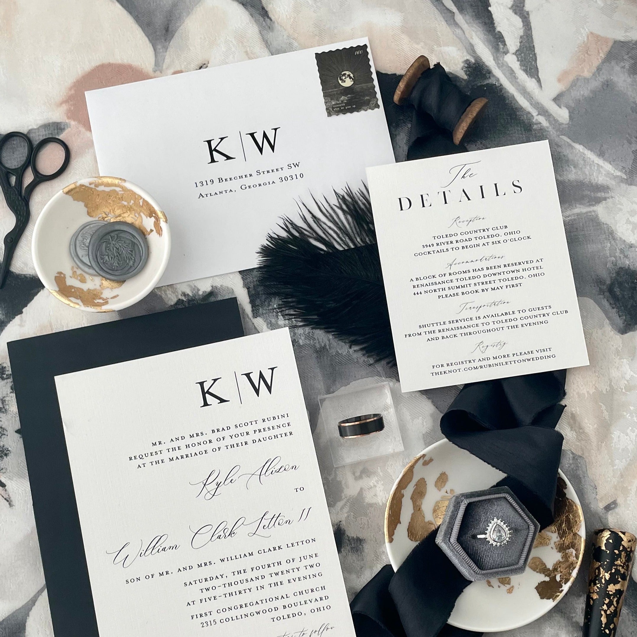 Black and gold wedding flat lay with wedding invitation, gray ring box, black ribbon, gray was seals in white and gold dish, and vintage black scissors - Wedding Flat lay props from Champagne & GRIT