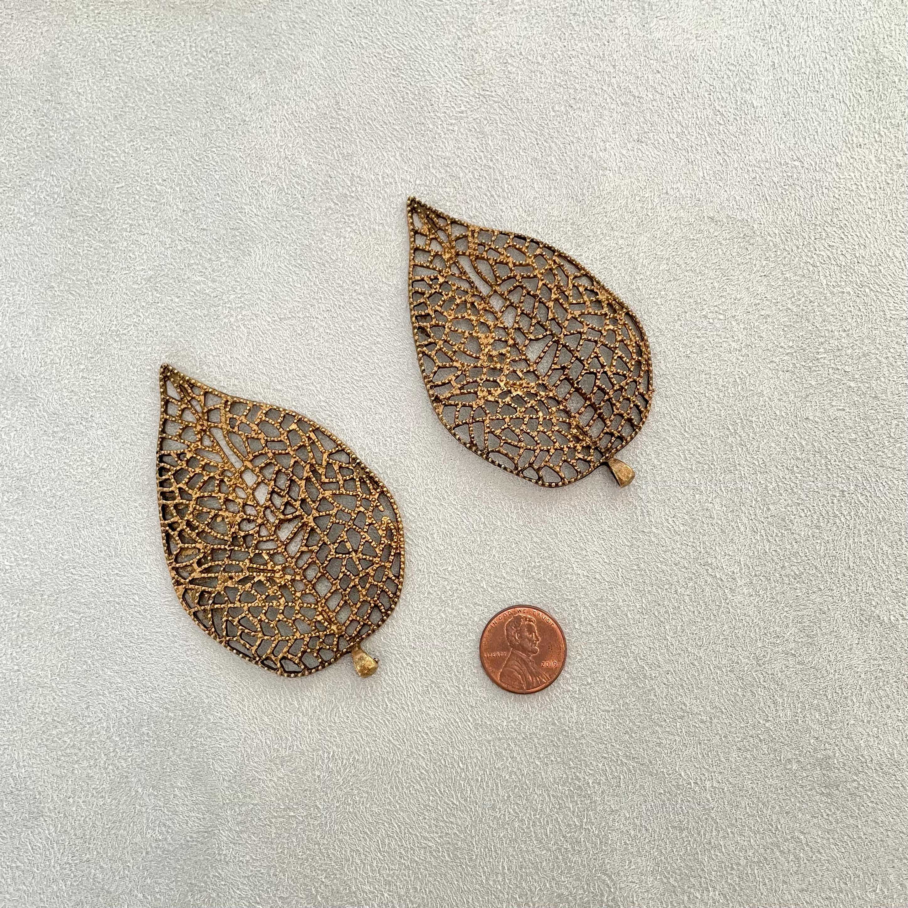  2 Large Coco Bronze metal leaves, penny beside for size reference - flat lay props from Champagne & GRIT