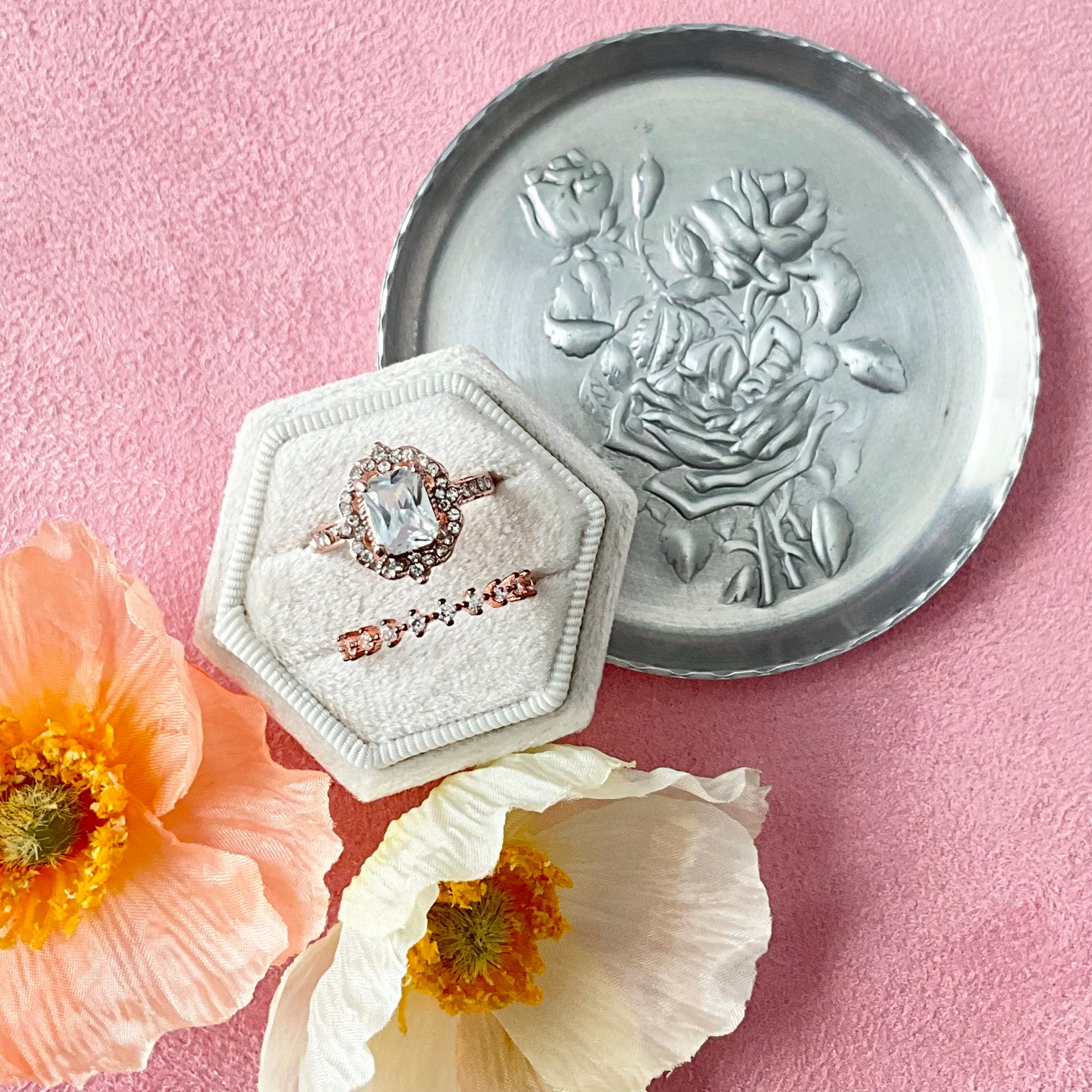 Silver dish with hexagon tan ring box and florals on pink styling mat - Flat lay props from Champagne & GRIT