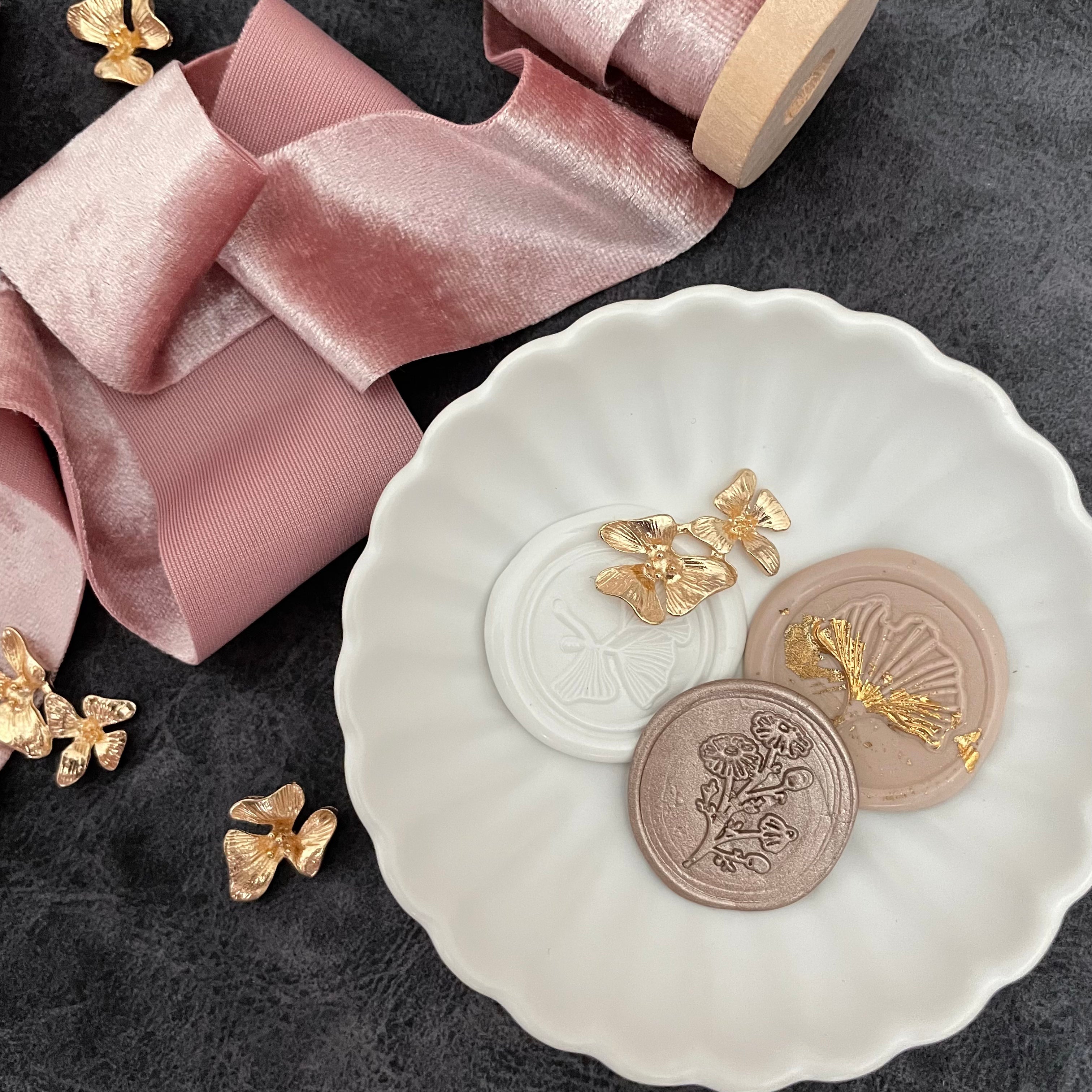 3 champagne wax seals in Matte white scalloped dish styled with dusty mauve ribbon - wedding flat lay props from Champagne & GRIT
