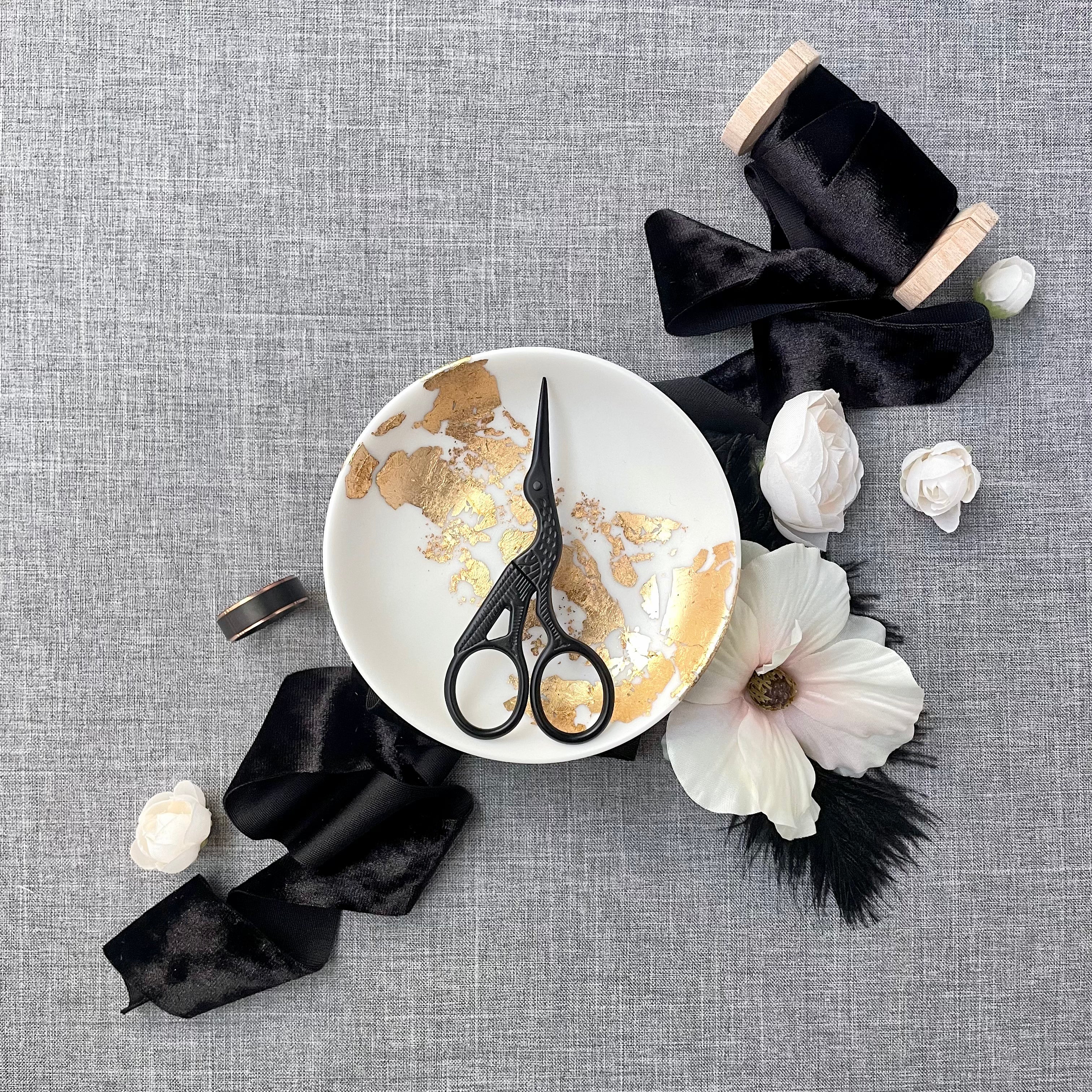 Modern Black Scissors with crane design styled in gold and white dish and black ribbon - Wedding Flat lay props from Champagne & GRIT
